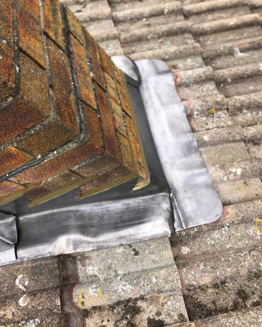 Lead flashing dressed round the base of a chimney