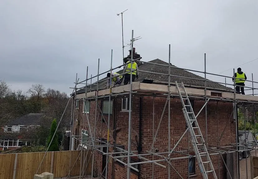 The Urban Roof Repairs team on the scaffold of a house