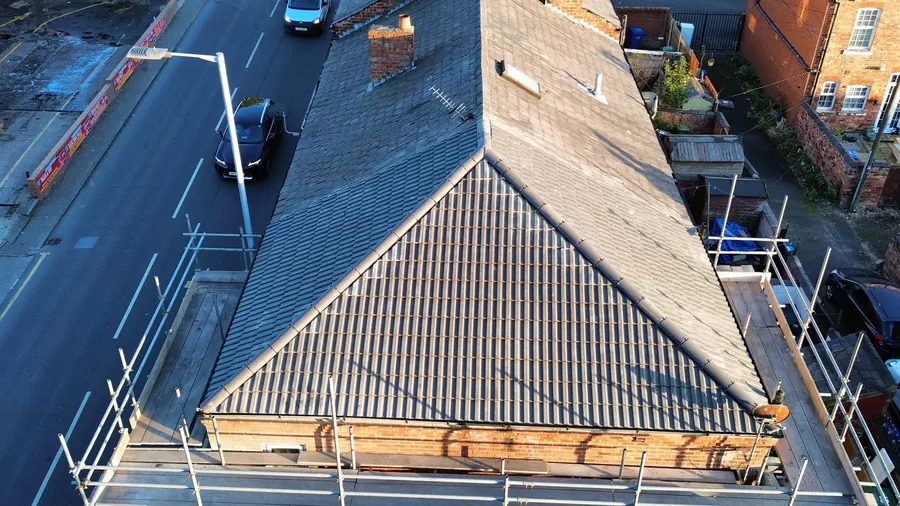 Drone view of a re-roofed terrace with new tiles and scaffold at the eaves