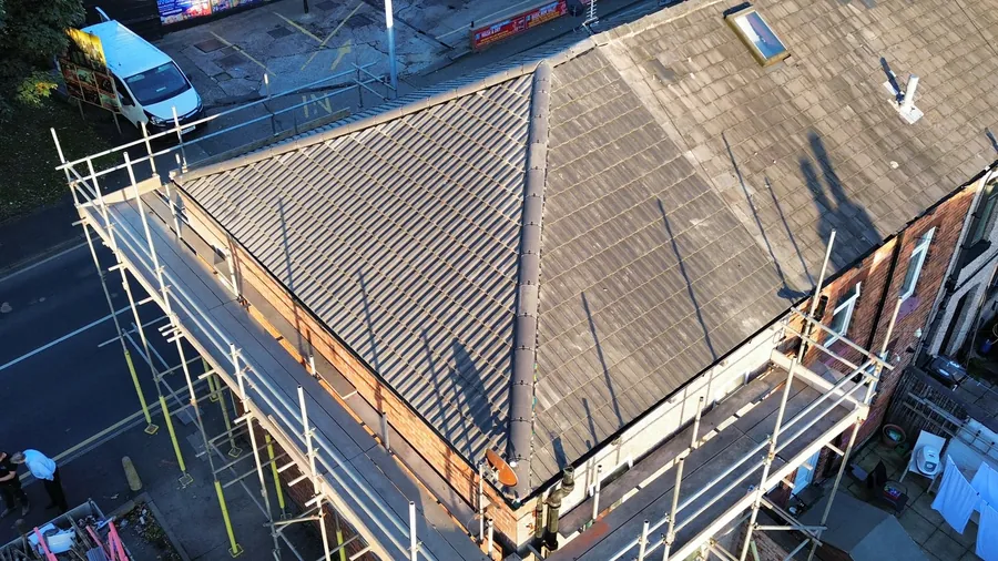 Re-roofed terrace house from above with scaffold and a terraced street behind
