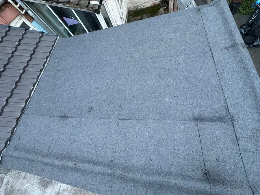 New felt flat roof next to a tiled slope