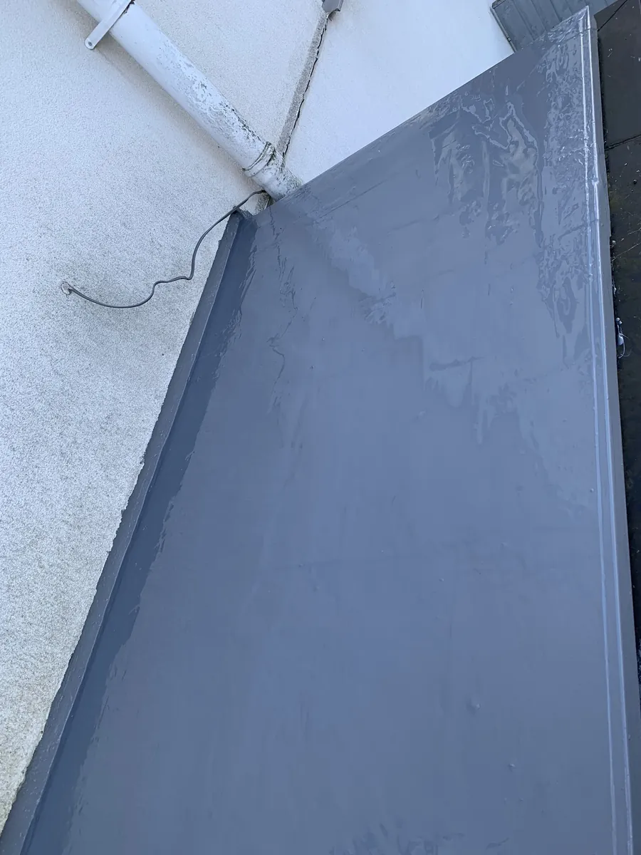 Grey flat roof covering dressed up the wall