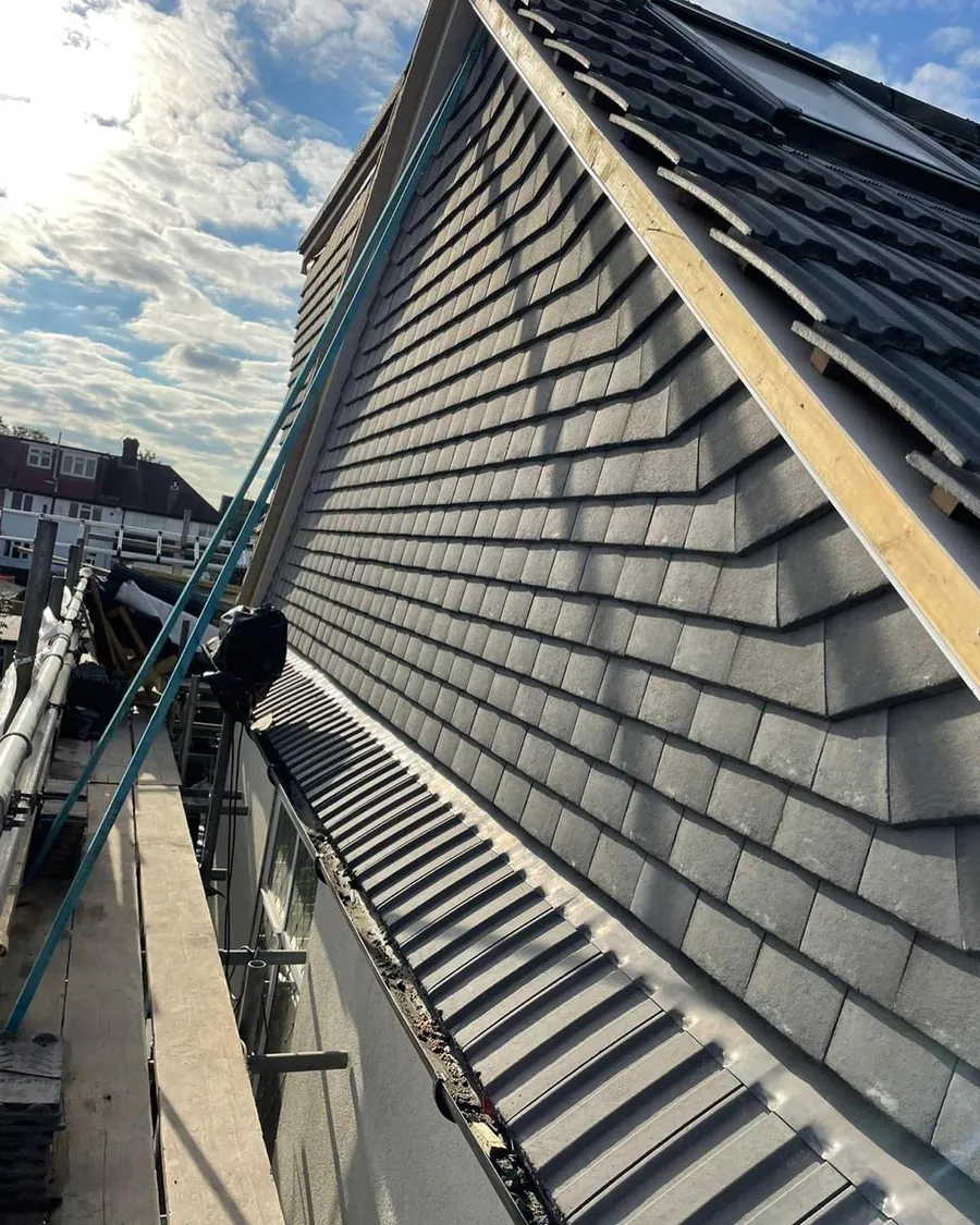 Grey tiles finished at the gable with ladders and scaffold