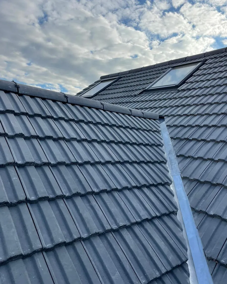 Grey interlocking tiles with a lead valley and roof windows