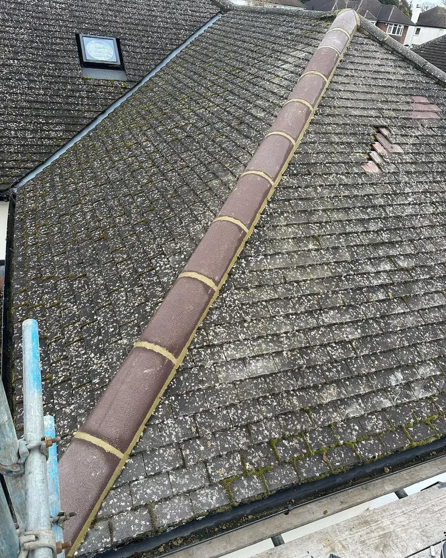 Mossy roof with a tired ridge before repointing