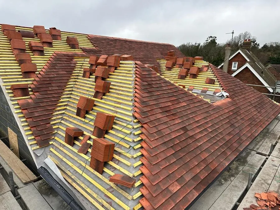 Red plain tiles loaded out on new battens during a re-roof
