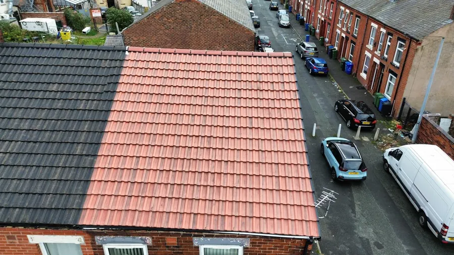 New red tile roof on a terraced house next door to a dark roof