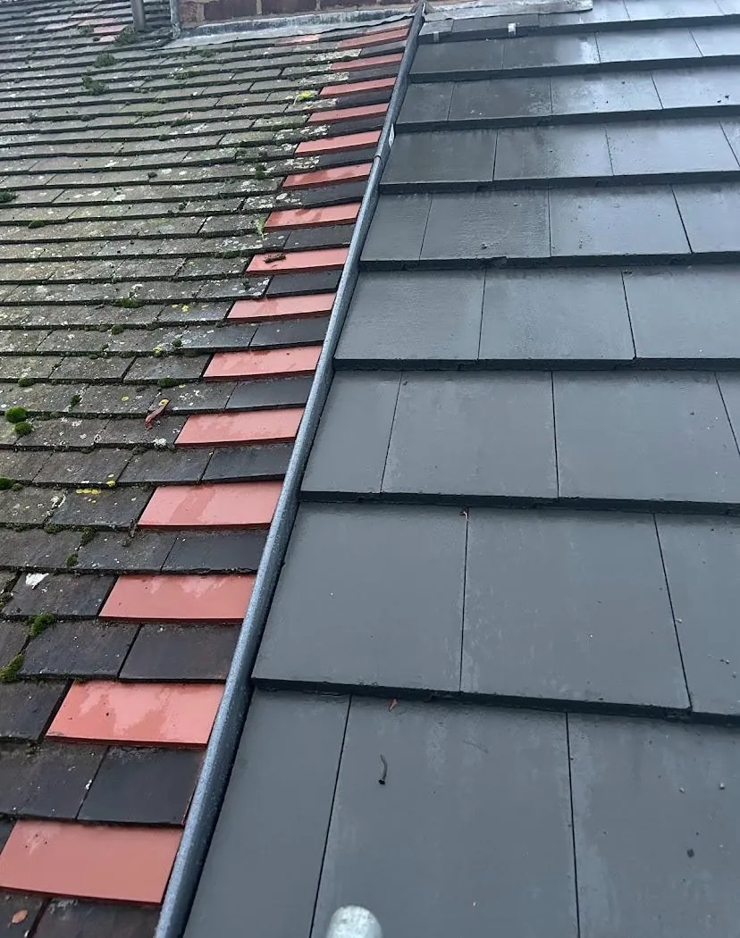Slate-effect tiles replacing old red tiles on a slope