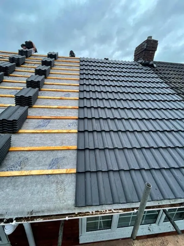 Grey tiles loaded out on new battens ready to lay